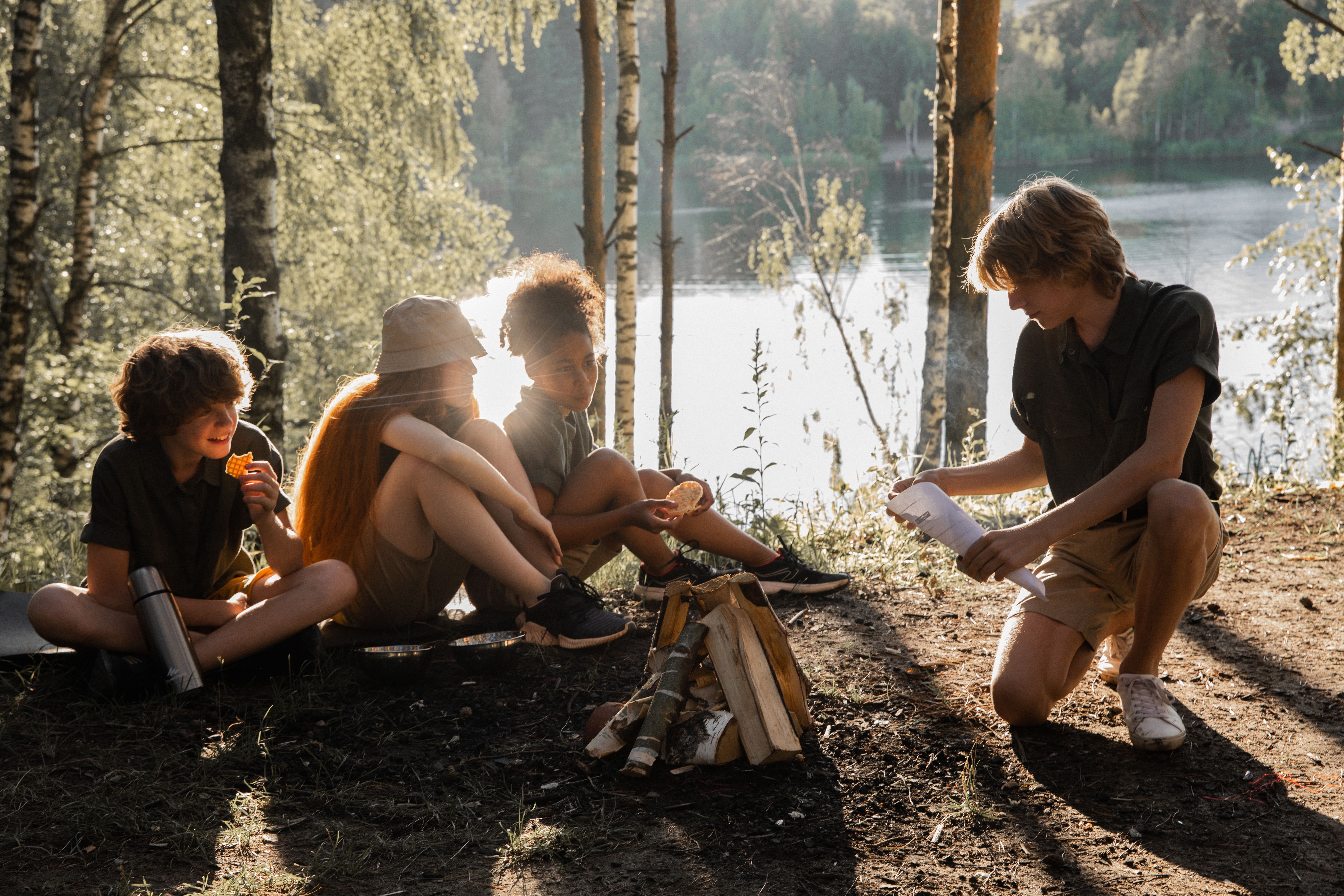 Kids gathered together by a lake in the forest