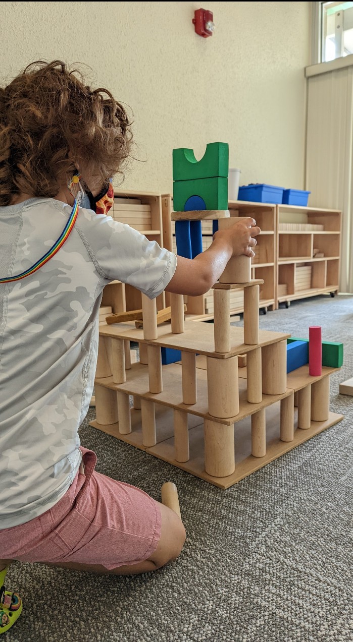 Child building a tower with wooden blocks